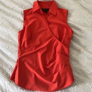 Orange, collared, sleeveless blouse.